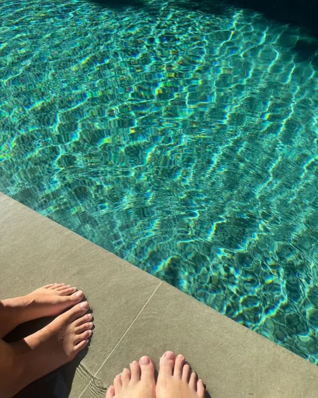 Gemma Chan relaxing beside a swimming pool.