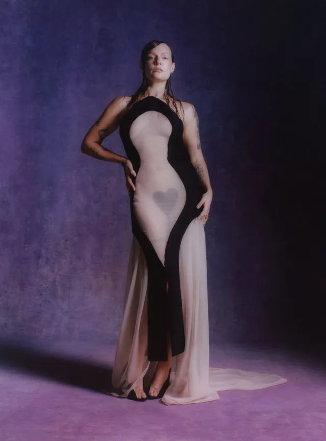 Tove Lo posing in a long pale and black gown and pointed heels.