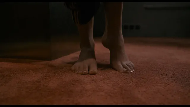 Daisy Edgar-Jones bare feet on a carpeted floor in a screen scene.