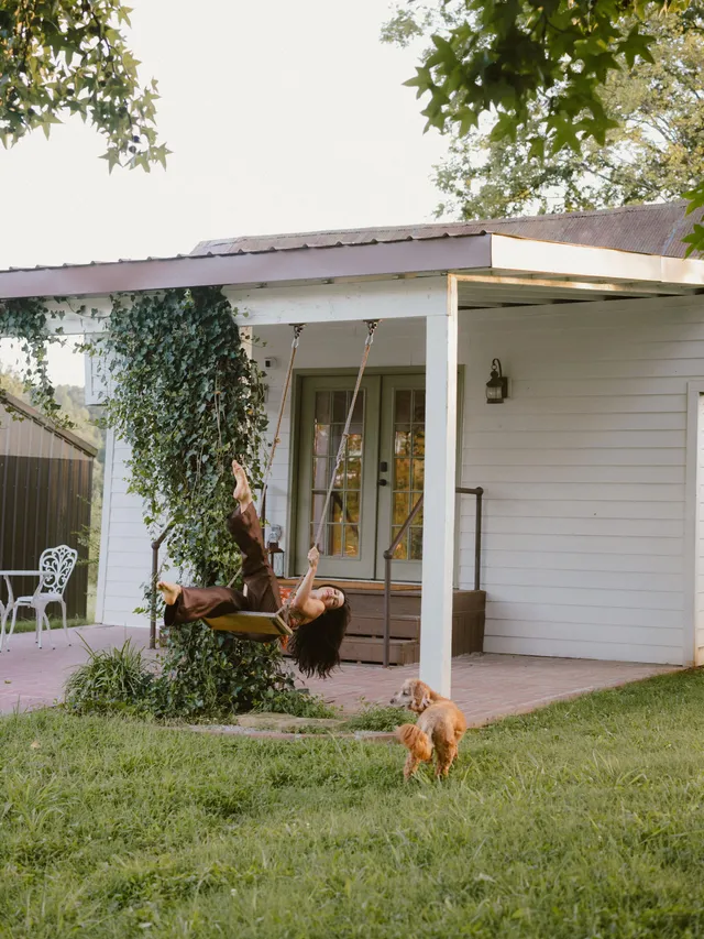 Danielle Campbell relaxing outside a house with a dog.