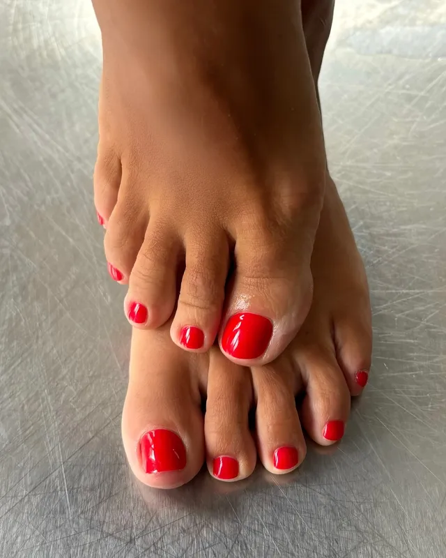 Lily Allen: close view of bare toes with red nail polish.