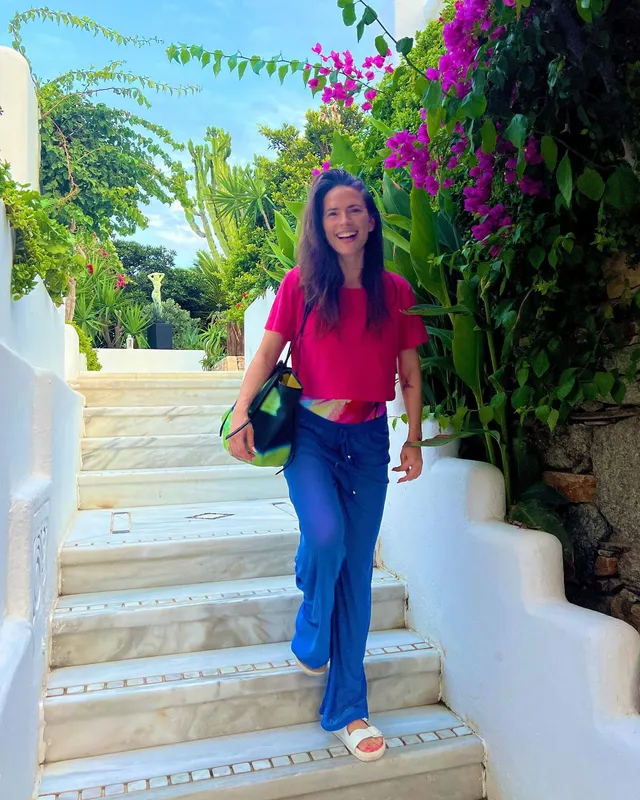 Hayley Atwell walking down garden stairs in jeans.