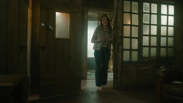 Elizabeth Gillies standing in a doorway during a screen scene.