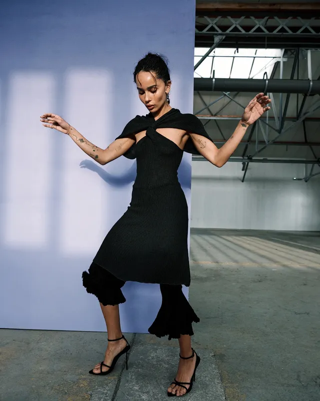 Zoë Kravitz posing in a black dress in a studio.