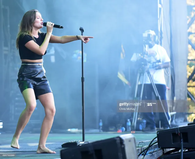 Tove Lo singing barefoot beside a microphone stand.