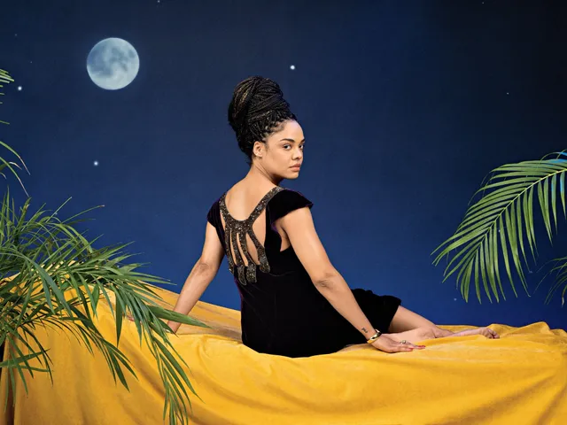 Tessa Thompson sitting on yellow fabric in a studio portrait.