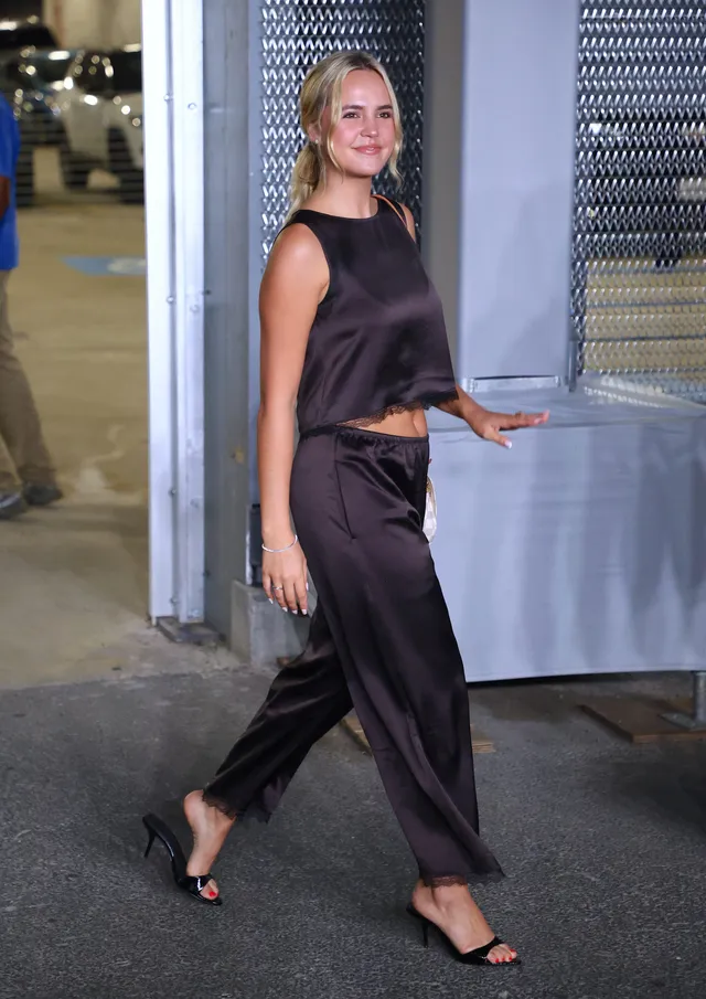 Bailee Madison walking outside in black heels.