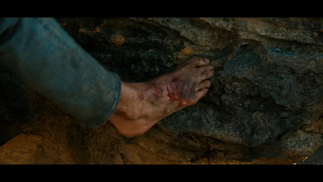 Charlize Theron a close screen detail of an injured bare foot.