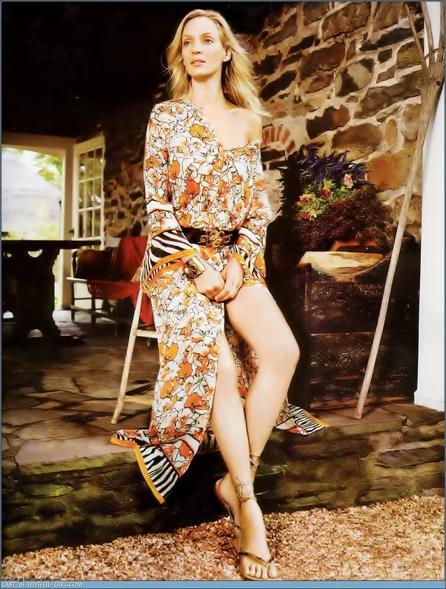 Uma Thurman sitting barefoot in a floral dress.