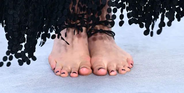 Margaret Qualley a front detail of black open toe heels.