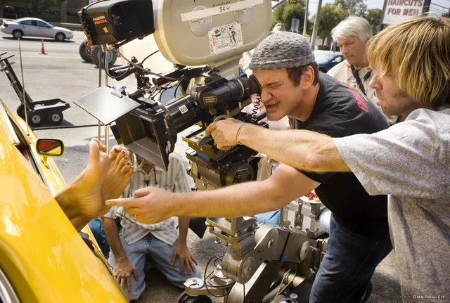 Rosario Dawson having a shot prepared beside a yellow car.