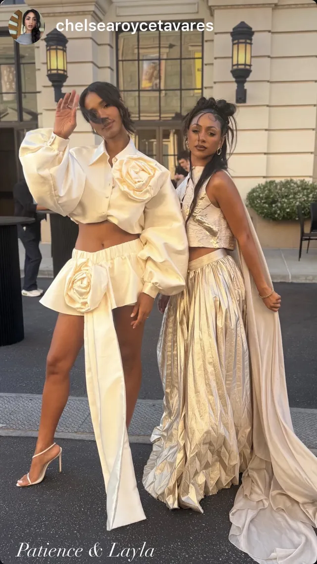 Greta Onieogou posing with a fellow performer in a long gold gown.