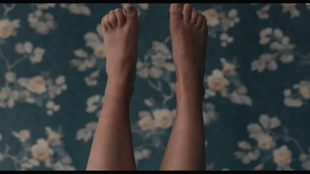 Sophie Turner a close view of bare feet against patterned fabric.