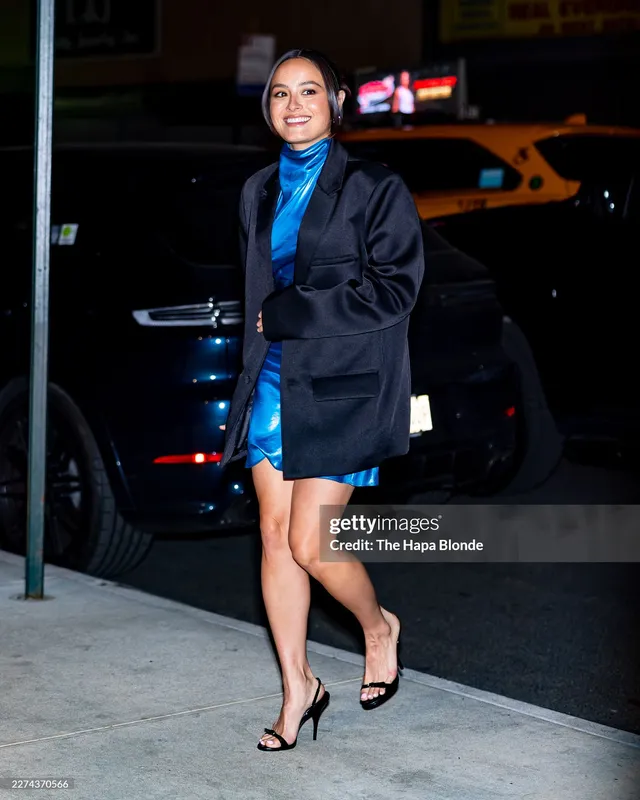 Chase Sui Wonders posing outside in a navy jacket and black heels.