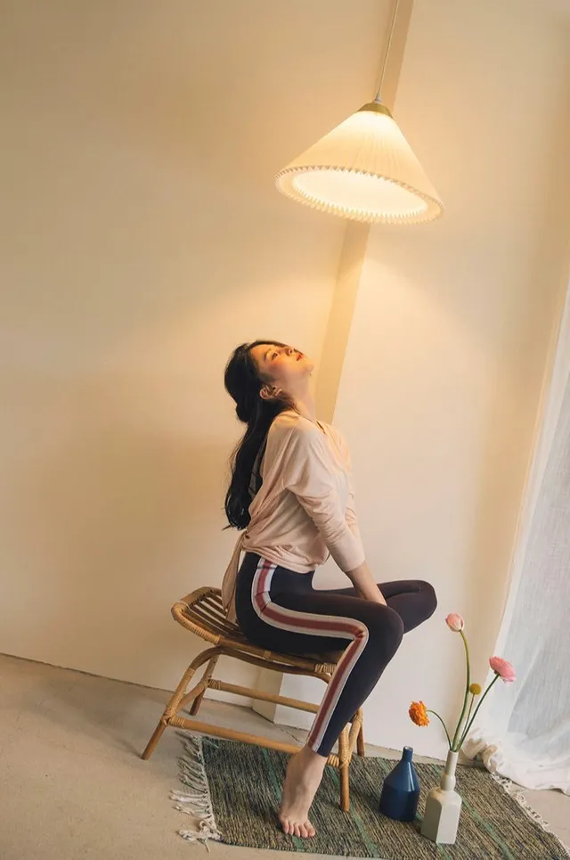 Han So-hee posing barefoot beside a chair.