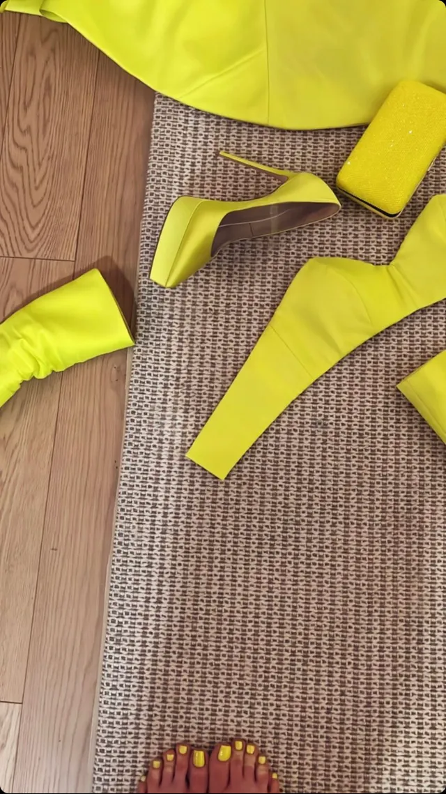 Gwen Stefani showing yellow-painted toenails beside bright footwear.