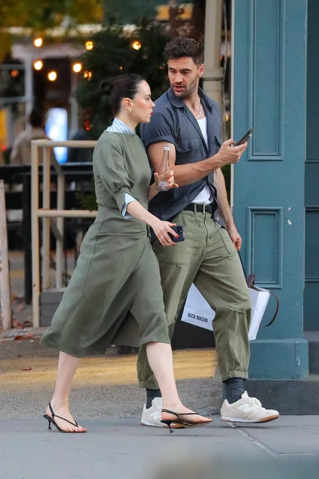 Daisy Ridley talking to a man while walking in sandals.