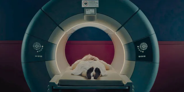 Chloë Grace Moretz lying with bare feet extended in a medical scanner.