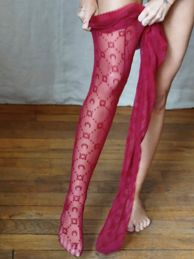 Miley Cyrus showing a bare foot beneath a pink outfit.