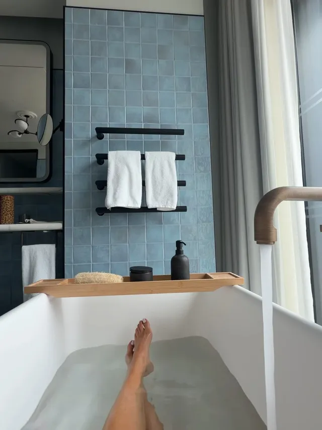 Rita Ora extending a bare foot from a bath.
