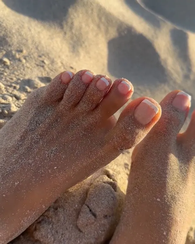 Shay Mitchell a close-up of sandy toes at the beach.