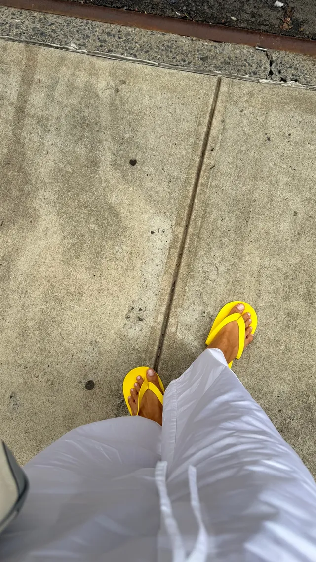 Irina Shayk yellow sandals with loose white trousers.