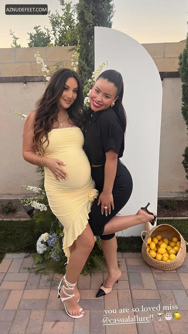 Cierra Ramirez in a black dress and pale strappy heeled sandals beside a friend wearing yellow.
