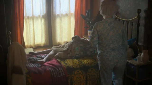 Gemma Arterton sitting on a bed in a dramatic screen scene.