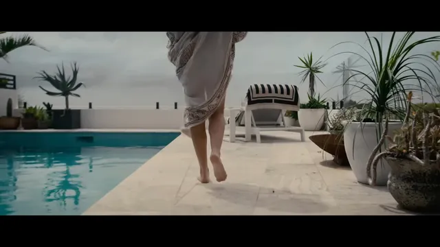 Teresa Palmer standing beside a swimming pool during a screen scene.