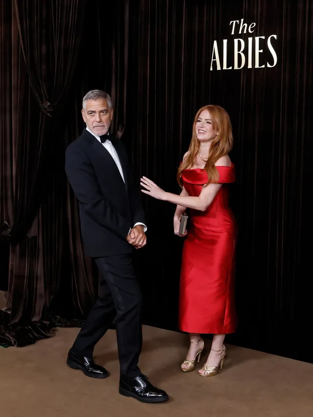 Isla Fisher posing beside a companion at an awards event.