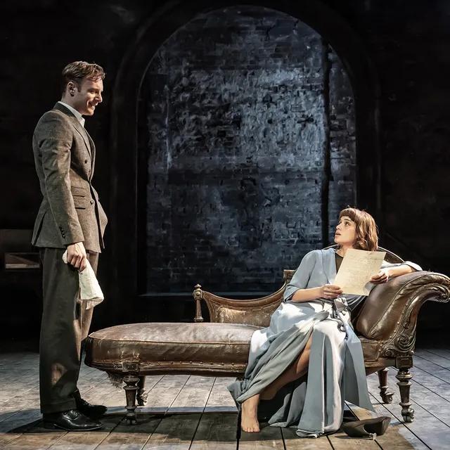 Anya Chalotra reclining barefoot on a chaise longue beside a man.