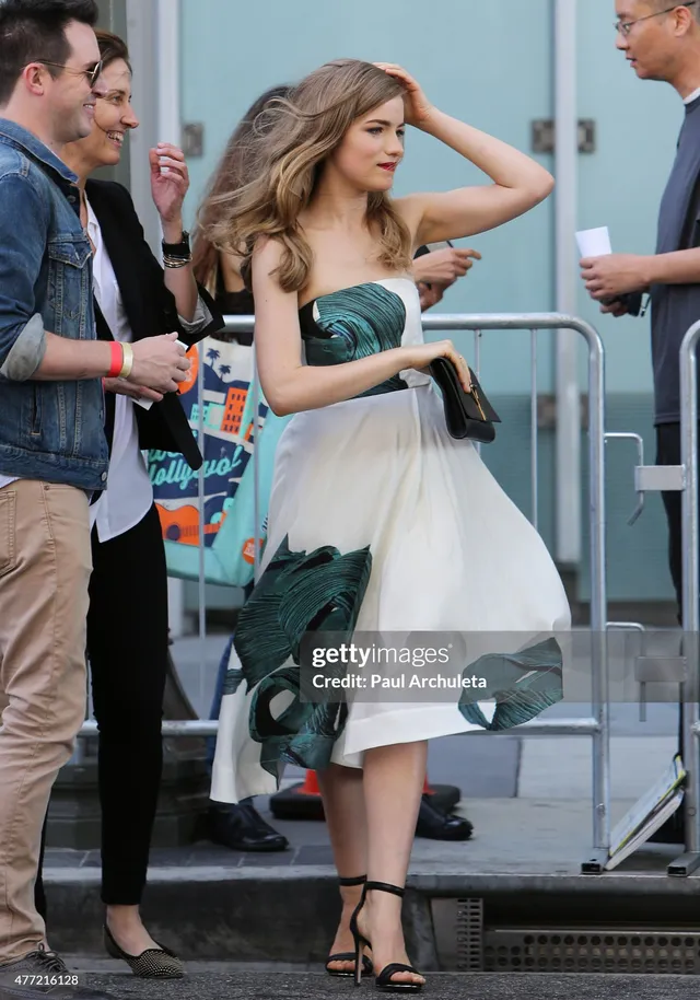 Willa Fitzgerald standing outdoors in a pale dress and black heels.