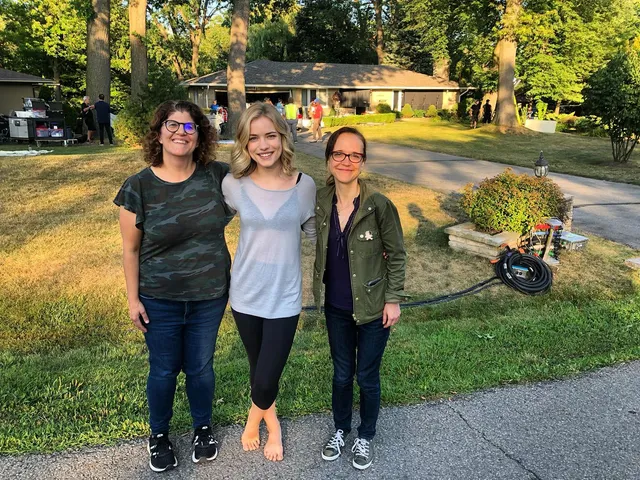 Willa Fitzgerald standing barefoot outdoors with companions.