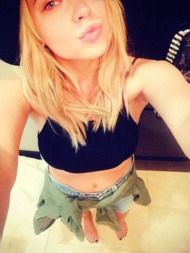 Ashley Benson taking a casual portrait in jeans and flip-flops.