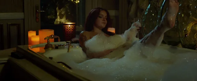 Ariel Winter sitting in a bubble bath during a screen scene.