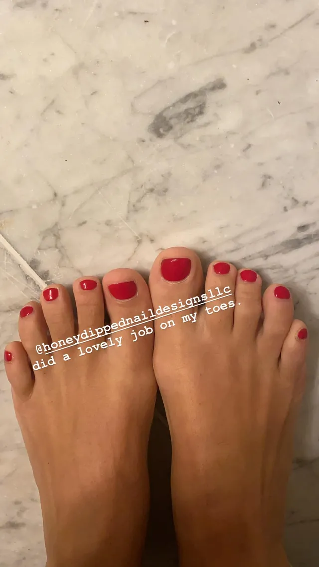 Lily Allen showing painted toenails on a marble floor.