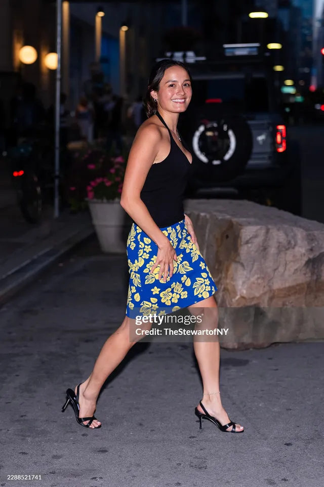 Chase Sui Wonders walking in a floral skirt and black heels.