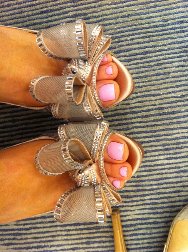 Ariana Grande a close view of jeweled heeled sandals and pink-painted toenails.