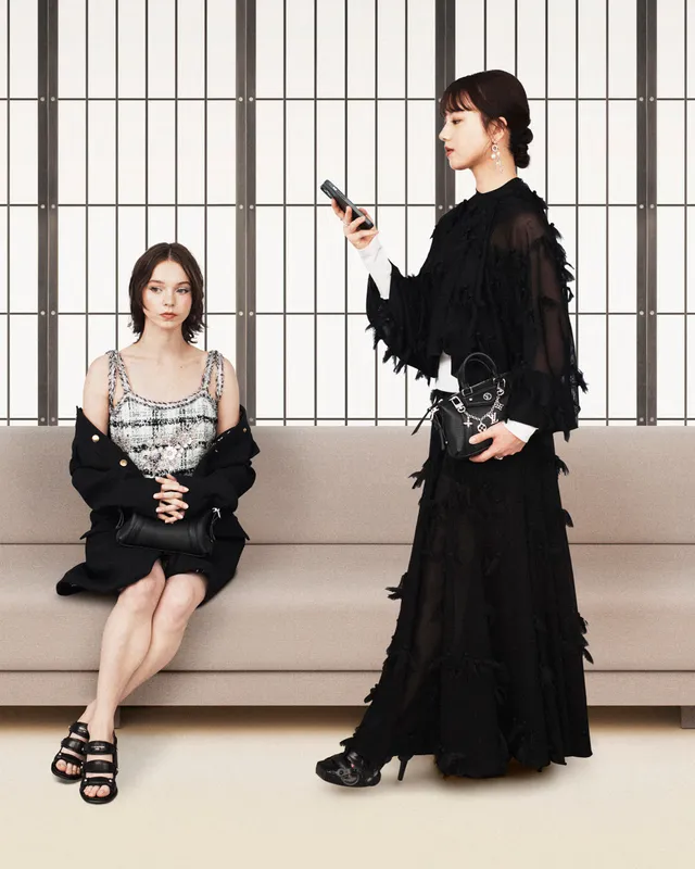 Emma Myers sitting beside another woman in black platform heels.