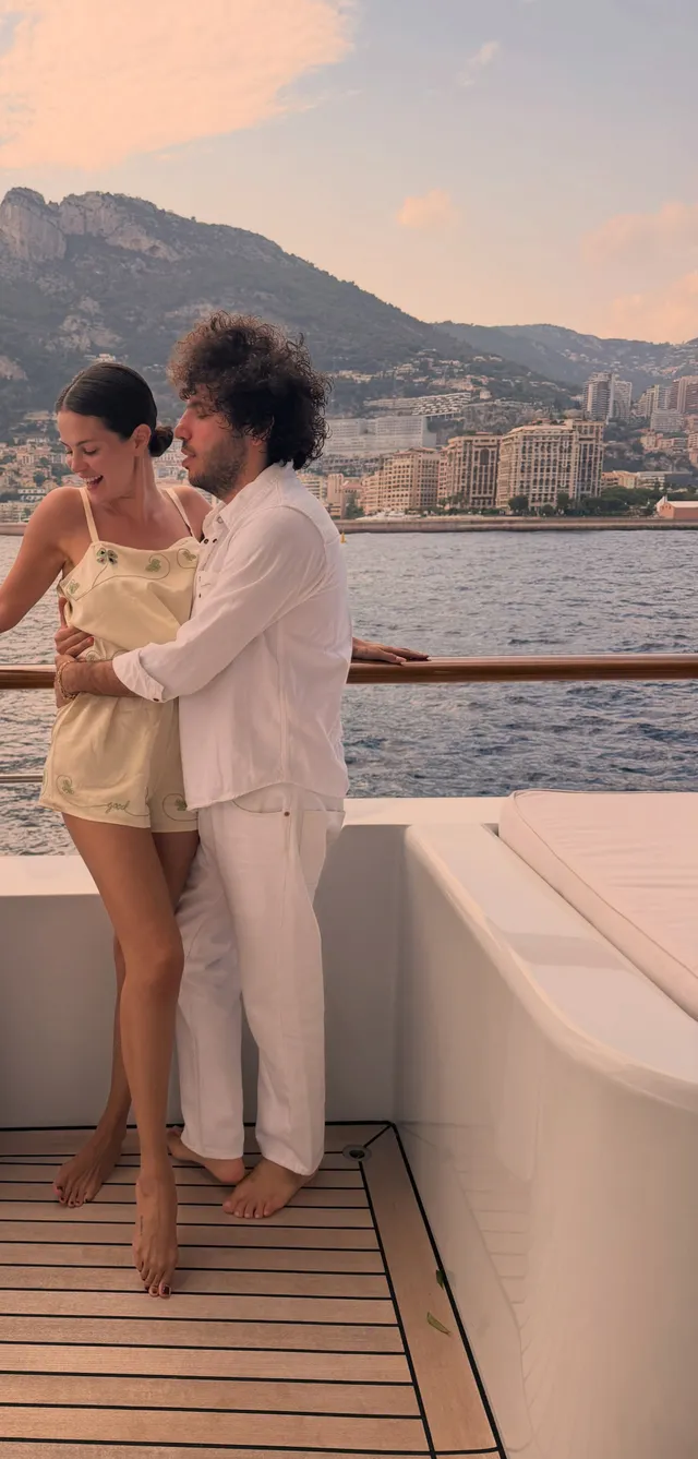 Selena Gomez standing on a boat beside a companion.