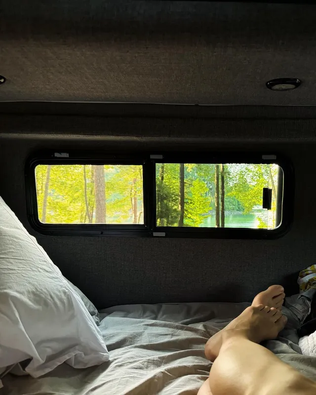 Yvonne Strahovski resting in a camper beside a window.