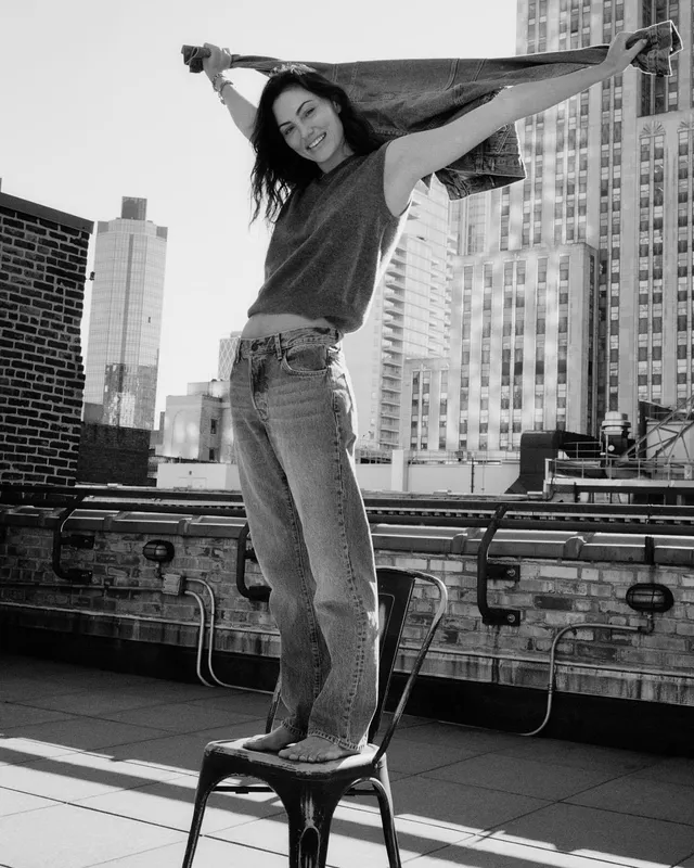 Phoebe Tonkin standing on a stool on a rooftop.