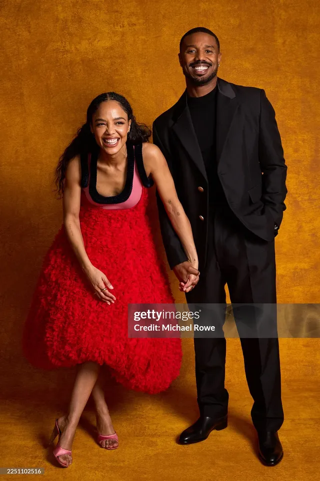 Tessa Thompson standing with a guest in a red dress.