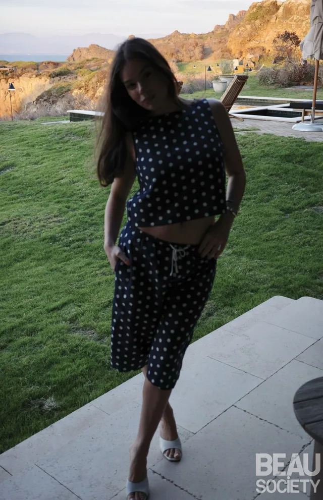 Hailee Steinfeld wearing a patterned two-piece outfit with white heels.