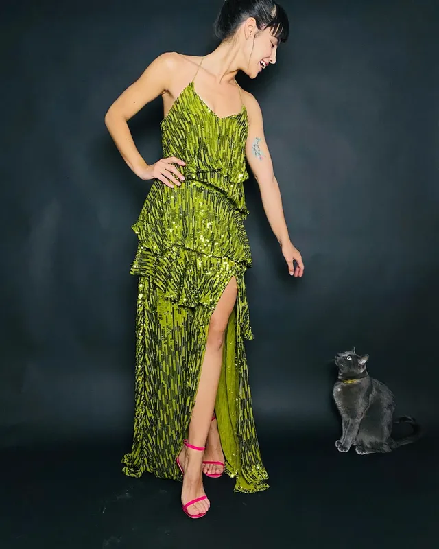 María Gabriela de Faría wearing a long green dress and pink heels.