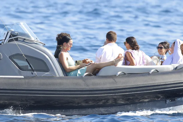 Katy Perry sitting with a group aboard a boat.