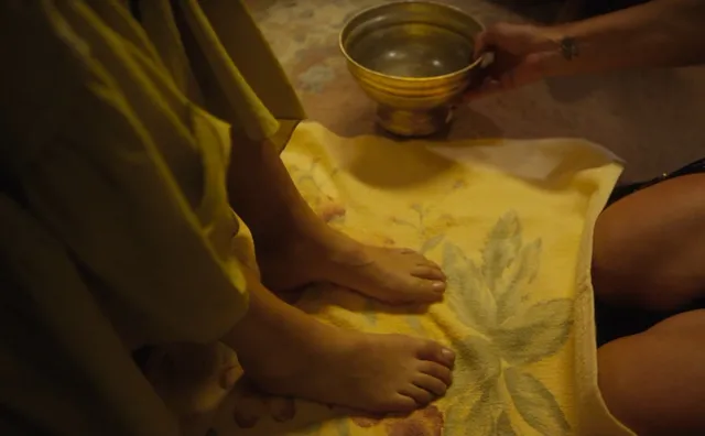 Melissa Barrera resting bare feet on a towel beside a bowl.