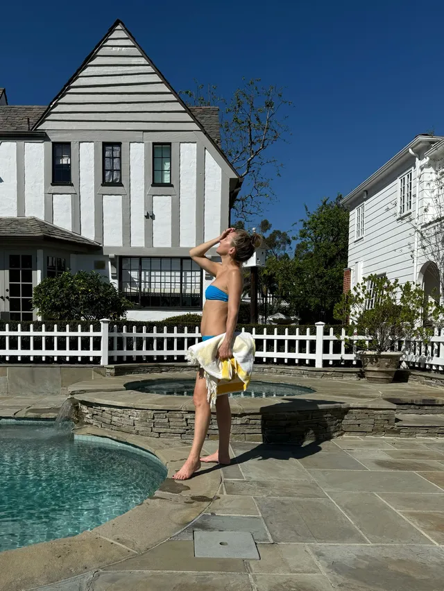 Kate Hudson standing beside a pool in a relaxed snapshot.