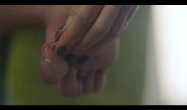 María Pedraza shown in a close-up of a bare foot held in a hand.