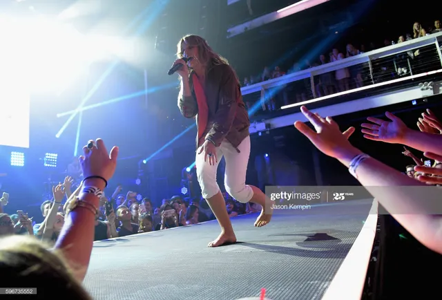 Tove Lo performing barefoot near the front of a stage.